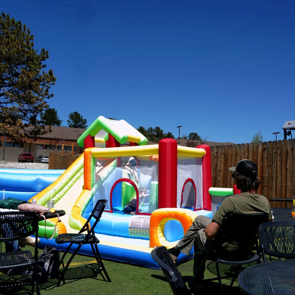 Families enjoying the inflatable playground at The Hummingbird Club